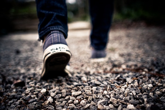 a pair of converse walking along a gravel path