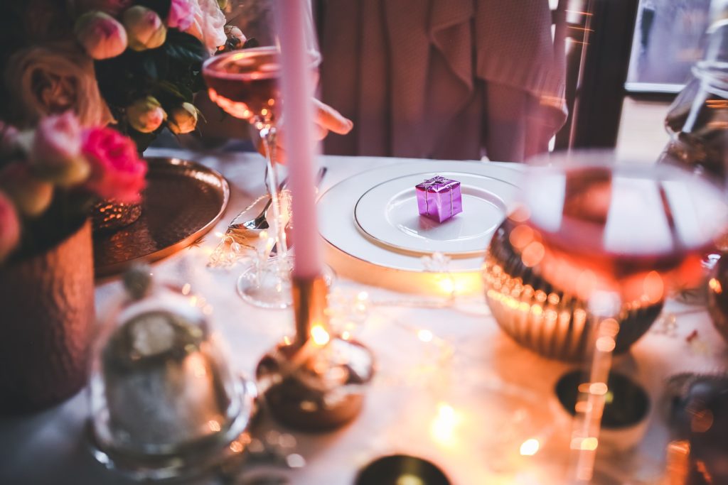 a tiny Christmas present on a plate at a formal Christmas dinner.