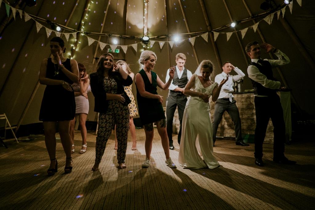 A group of friends dancing with the bride at her wedding.
