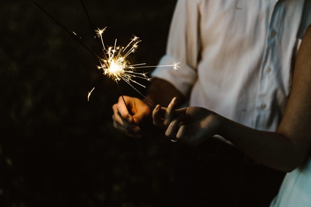 A couple lighting firecrackers together.