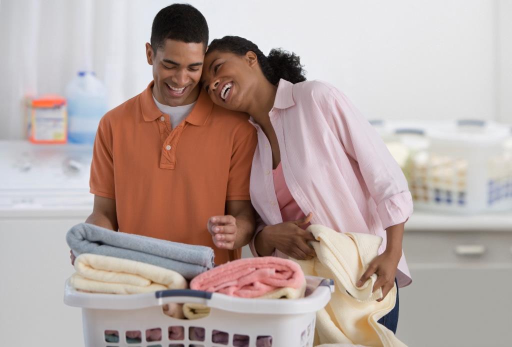 A couple folding laundry together.