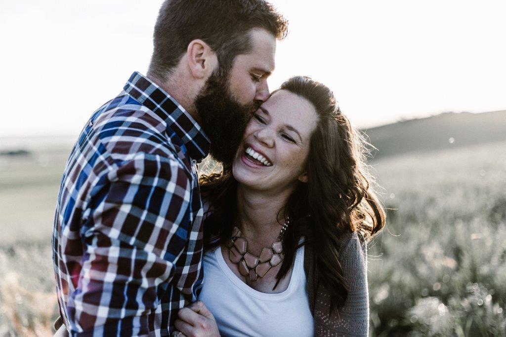 A man kissing his wife on the cheek.