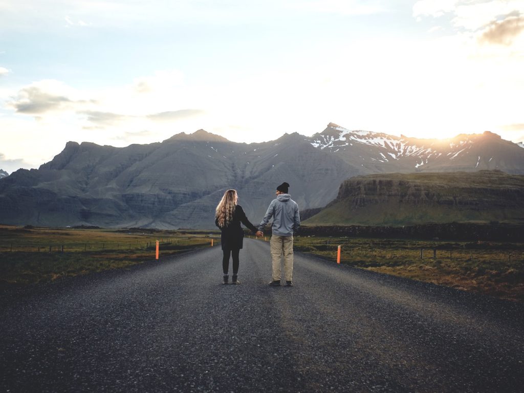 A couple holding hands and staring into the distance.