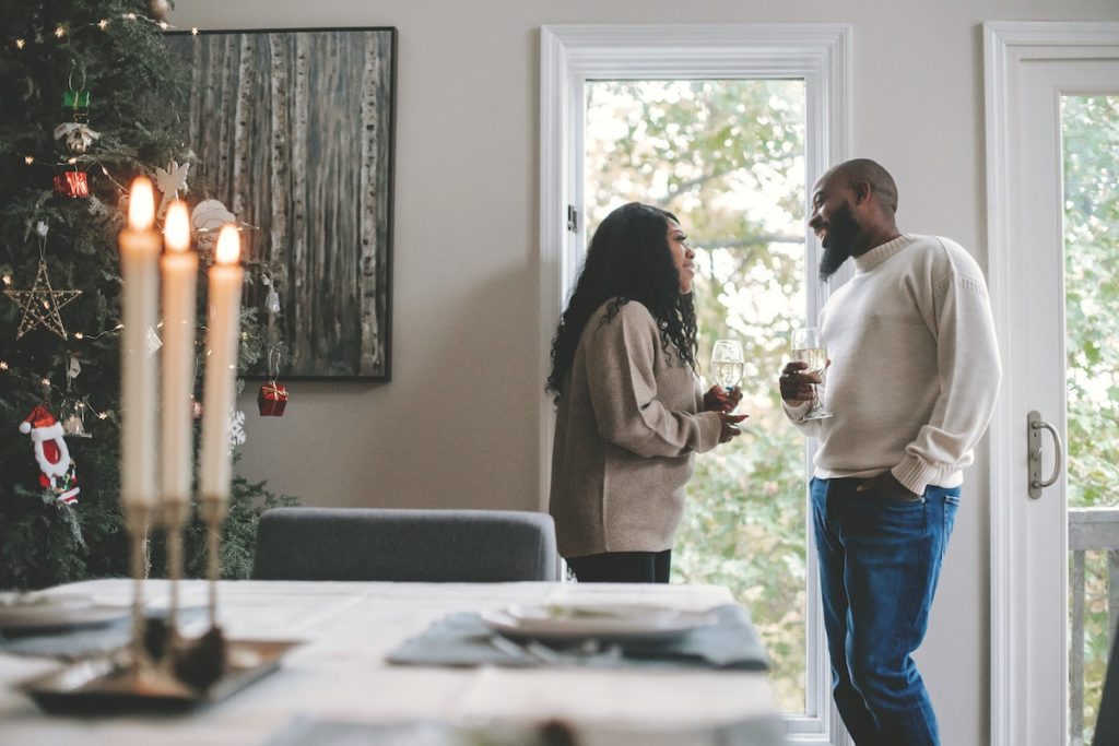 A couple smiling while drinking wine.