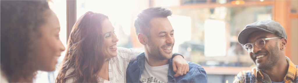Smiling young couple friends hanging out in cafe cropped to show only faces