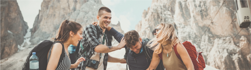Two couples laughing together after a mountain hike