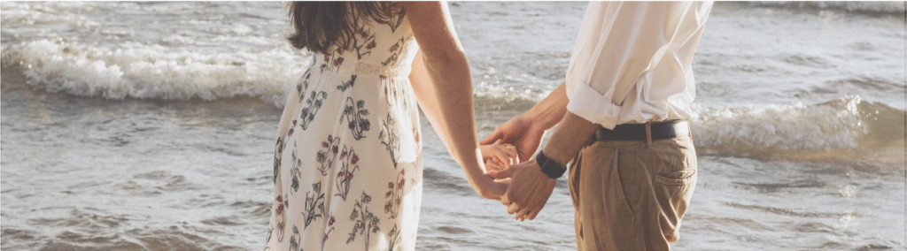 Couple holding hands on the beach in the summer