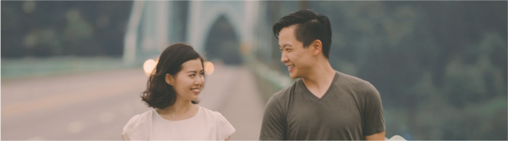 Cheerful couple walking together across a bridge