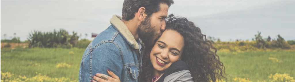 Couple hugging in field