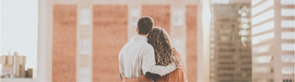 man and woman hugging each other looking at skyline