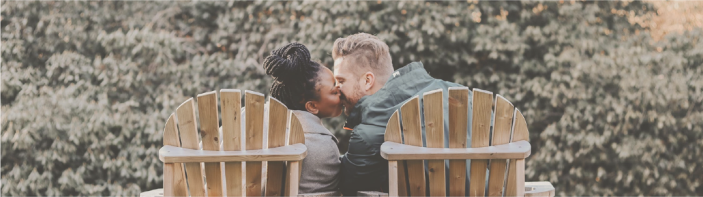 Couple Sitting on Deck Chairs and Kissing