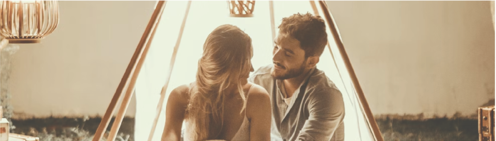 couple sitting inside tent with lights
