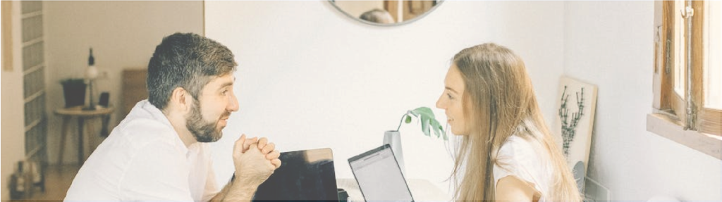 Couple sitting across table talking